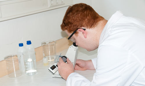 Laborant aan het werk met de Abbe-refractometer